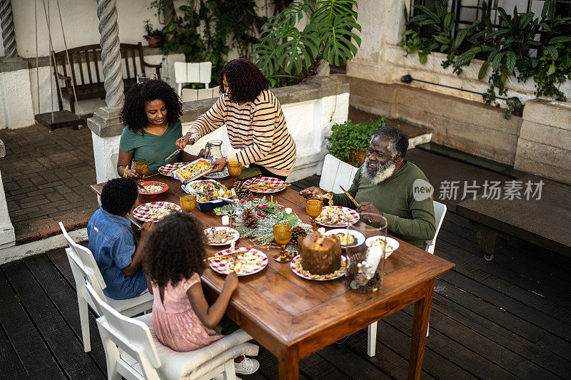 祖母在圣诞节的户外午餐给家人提供食物