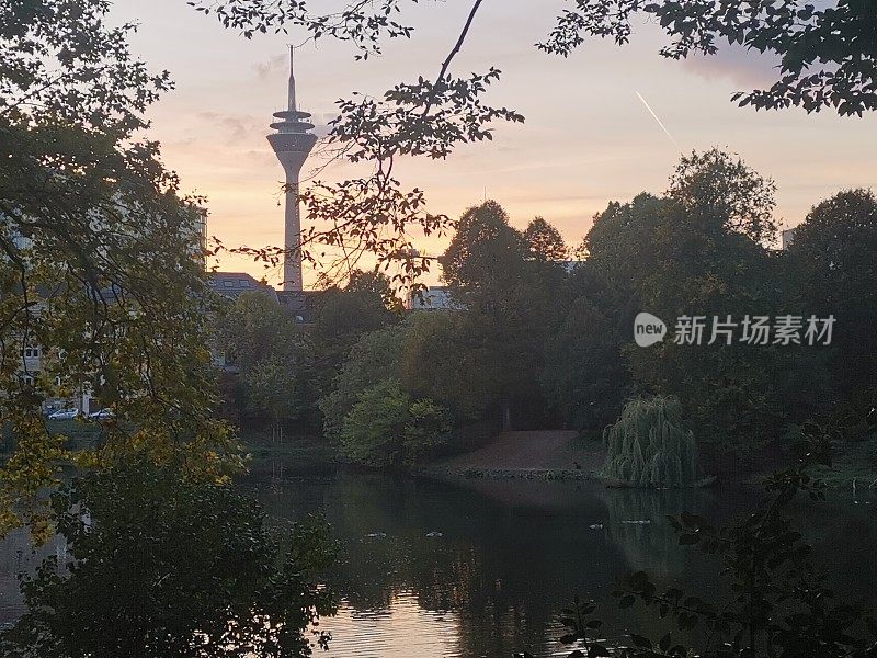 Düsseldorf公园和莱茵塔的背景在日落时的美丽色彩