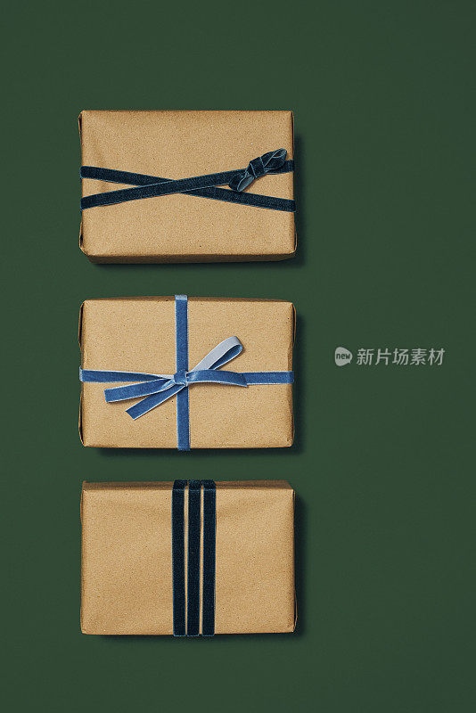 三个精心包装的礼品盒与不同风格的丝带