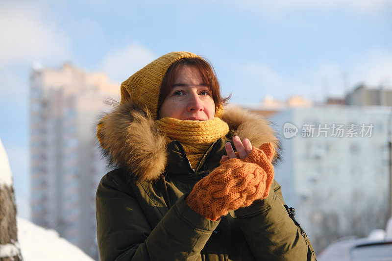 冬天的街上，一个女人在戴手套