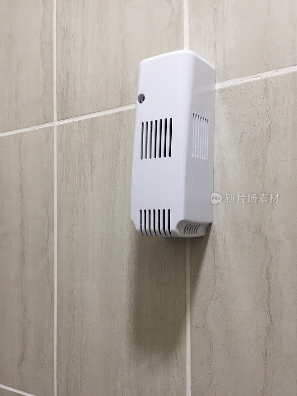 自动空气清新剂挂在浴室的墙上
