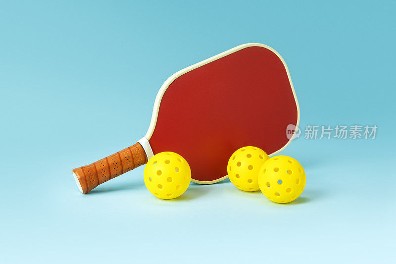 红色Pickleball球拍和黄色球在蓝色的背景