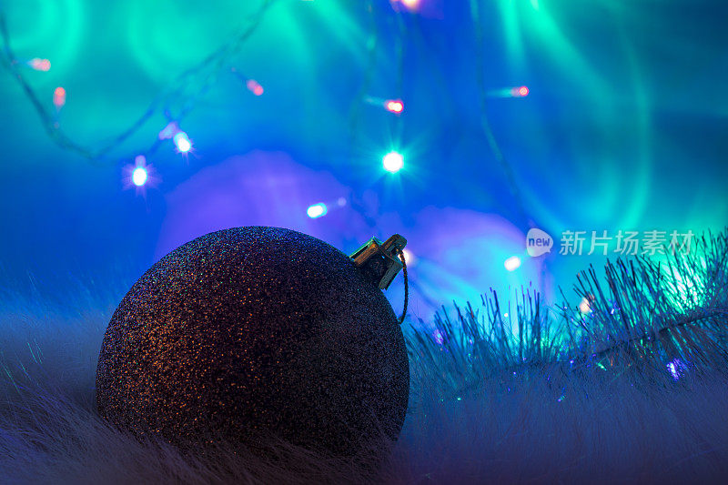 圣诞节灯泡。金球圣诞装饰上绿松石，蓝色的背景。