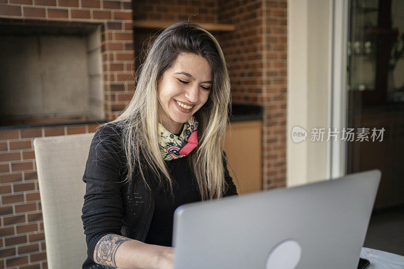 女性在家使用笔记本电脑和智能手机工作