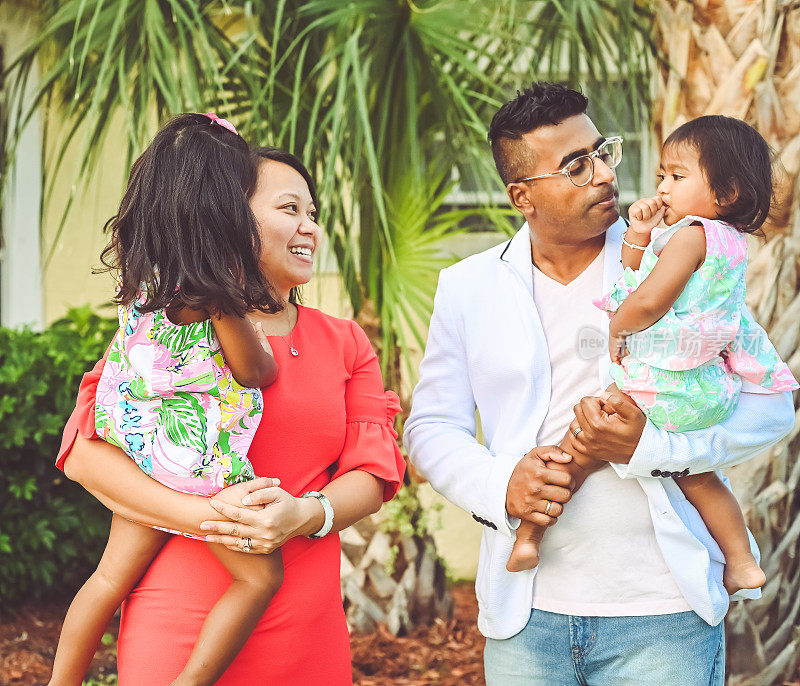 幸福的多元文化家庭，爸爸妈妈和两个女儿在欢快的肖像