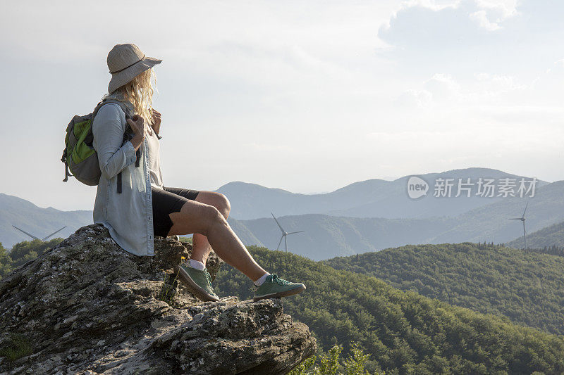 女徒步旅行者在日出时在观景台放松