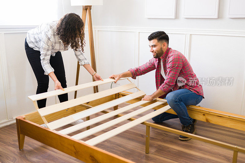 幸福的夫妇在建造一个自组装的床架时玩得很开心