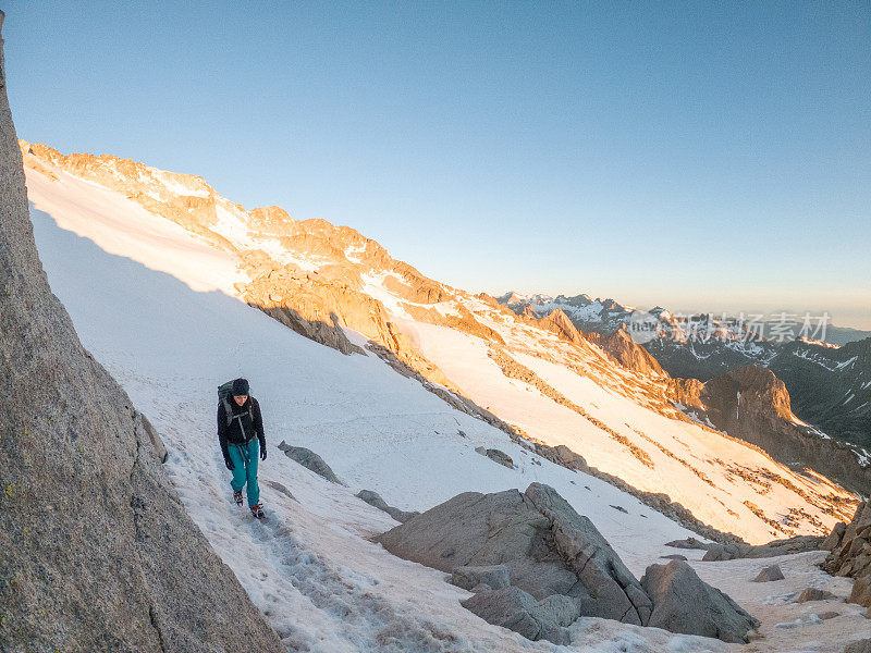 女登山者在雪道上攀登山峰