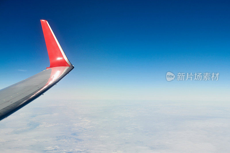 飞机飞过云层，从飞机窗口俯瞰空中，厚厚的白蓝色云层