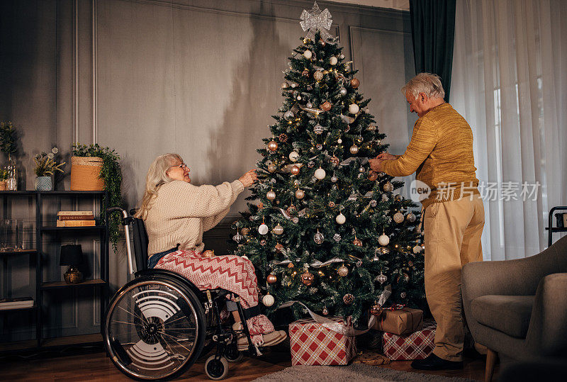 老夫妇在家里装饰圣诞树