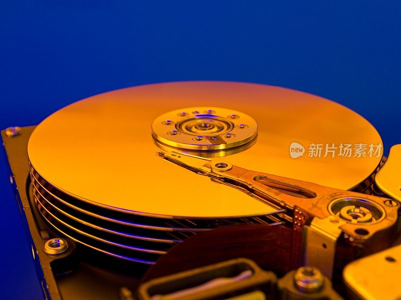 闪亮的金色硬盘驱动器盘片在一个蓝色的背景