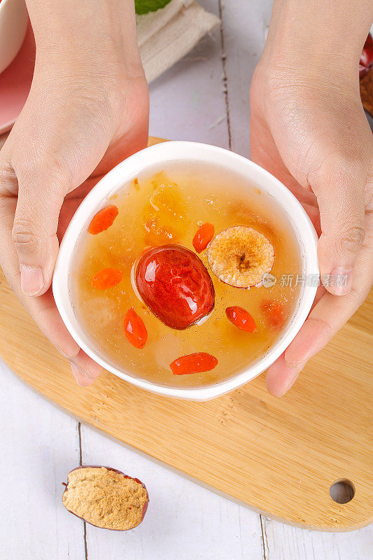 手里端着一碗红枣枸杞桃胶雪燕皂角米羹