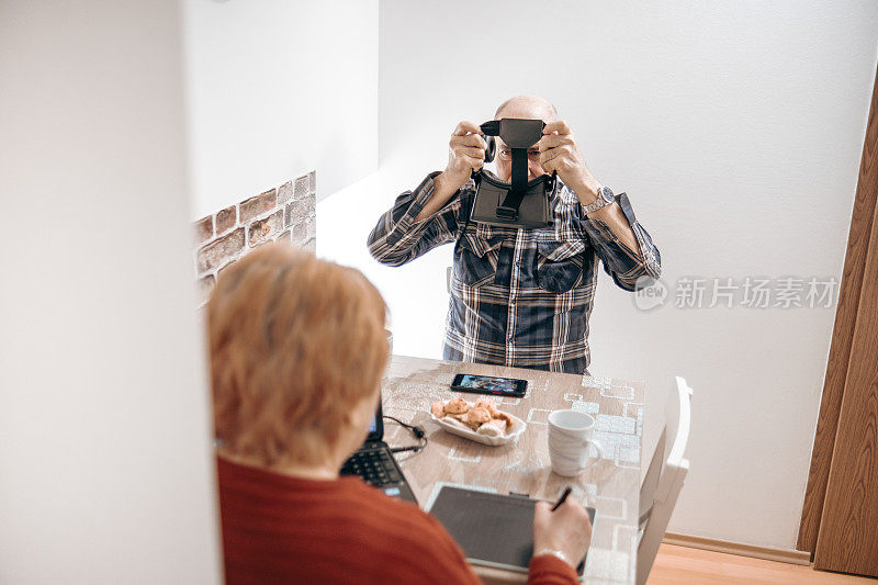 一位惊奇的老人在使用后摘下VR眼镜