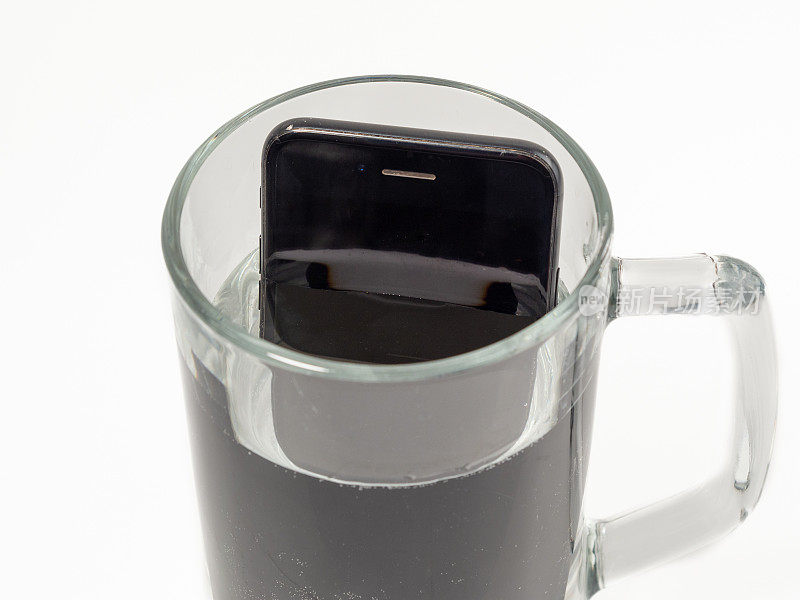 把智能手机放在一杯水里。智能手机掉进水里了。