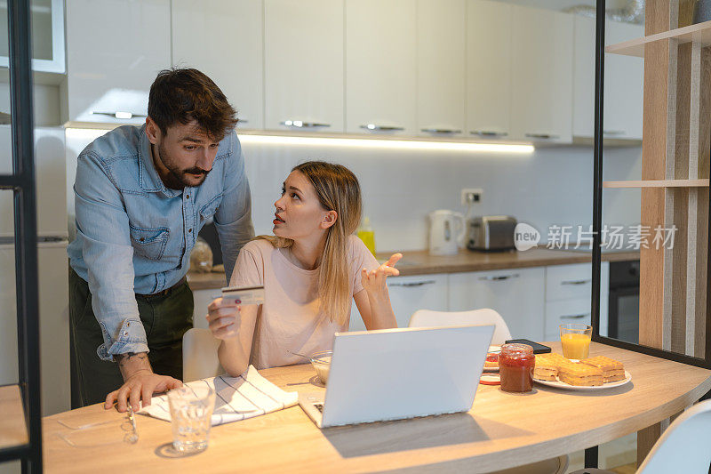 一对夫妇在家用笔记本电脑在网上预订房间