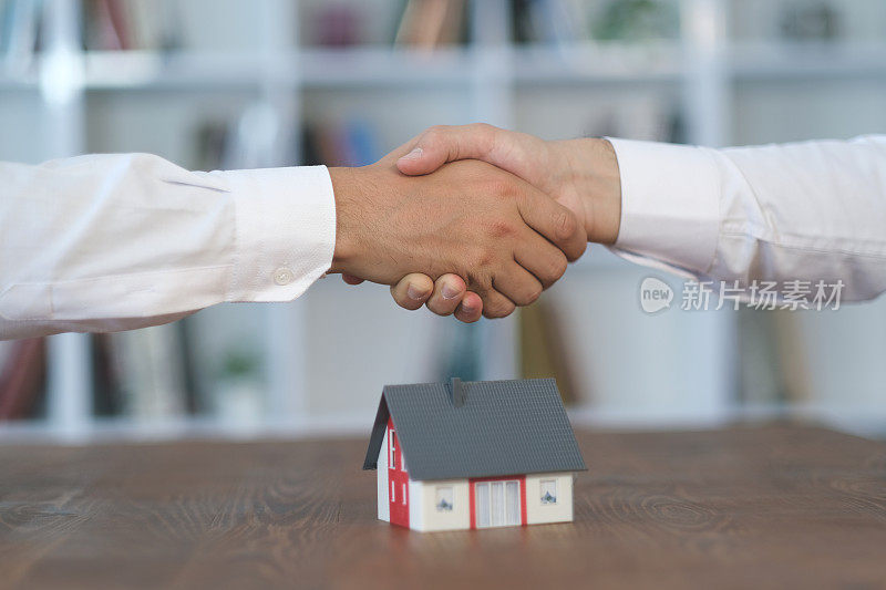 销售代表与客户正在握手并签署协议
