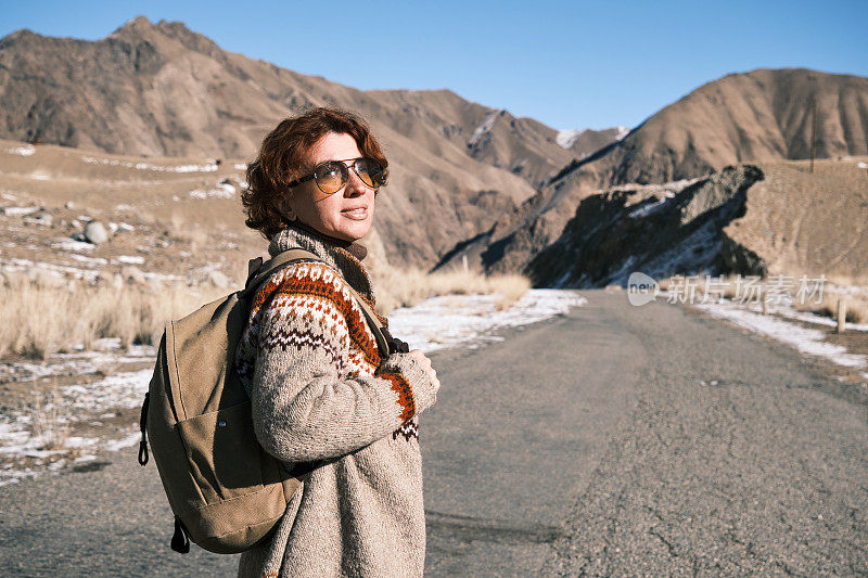 冬季，女游客(46岁)走在山口路上(春阿蜀山口，约4000米)。