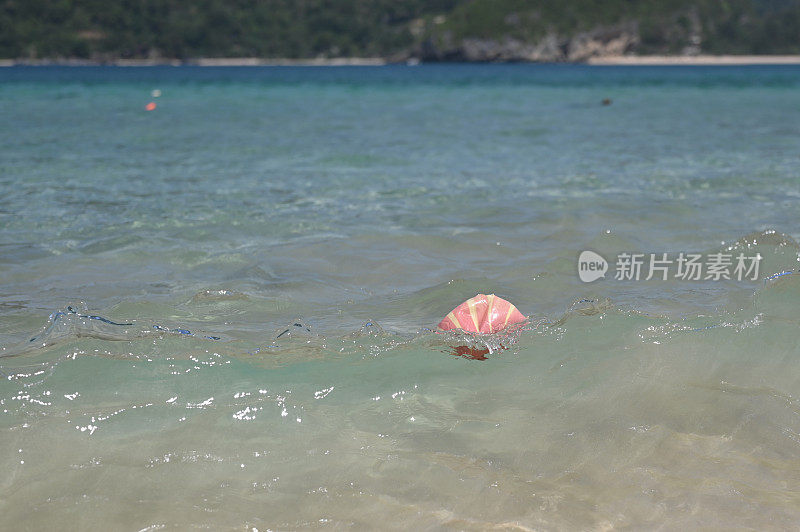 破碎的塑料球漂浮在海里