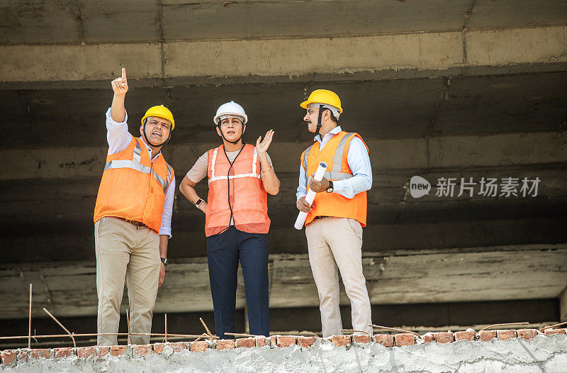 同事们在工地讨论建筑方案