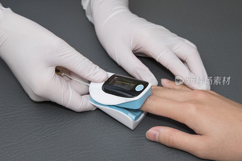 医生用脉搏血氧仪测量脉搏率和氧水平