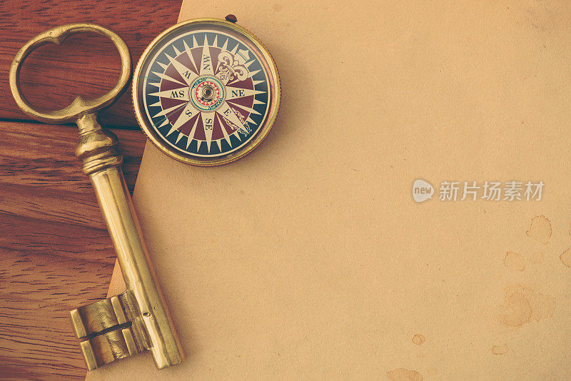木制书桌上的古董钥匙和指南针