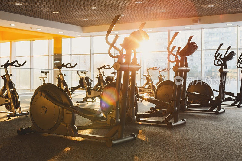现代化的健身房内部配备健身器材，椭圆机健身锻炼