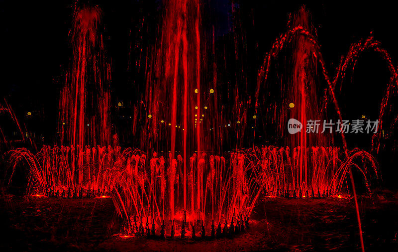 晚上的城市公园。发光的喷泉