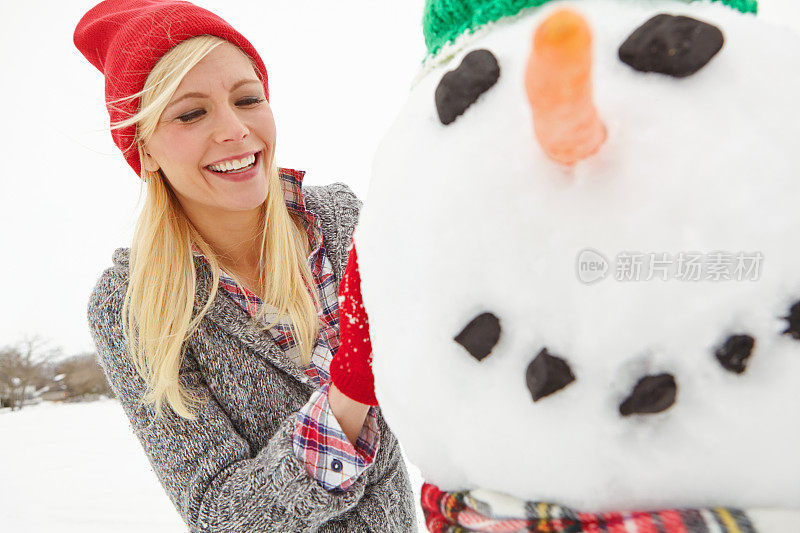 给她的雪人做最后的修饰