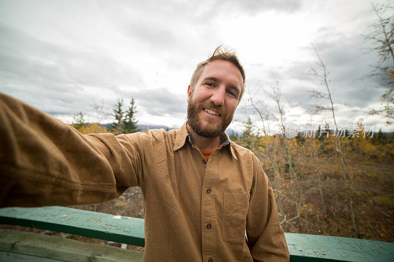 一个愉快的年轻人在加拿大徒步旅行自拍肖像-秋天