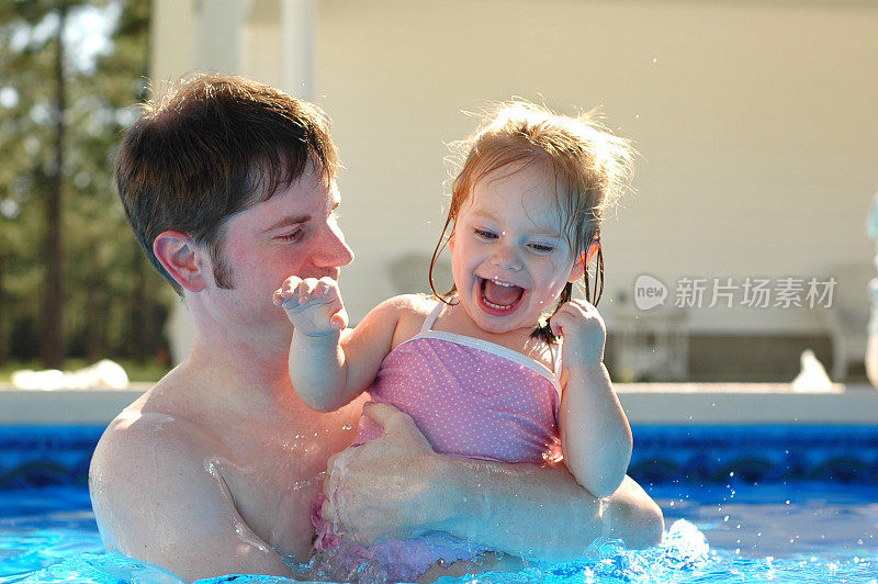 爸爸和女儿在游泳池里玩