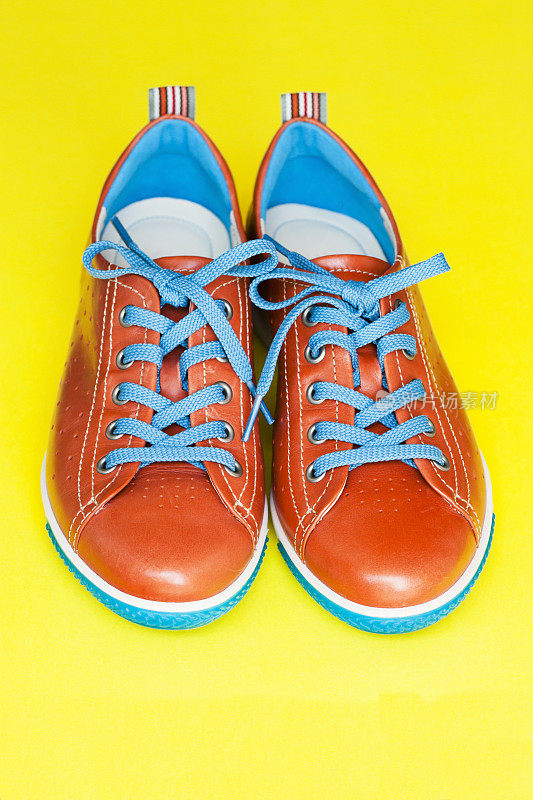 一双橙色皮鞋与蓝色鞋带，复制空间