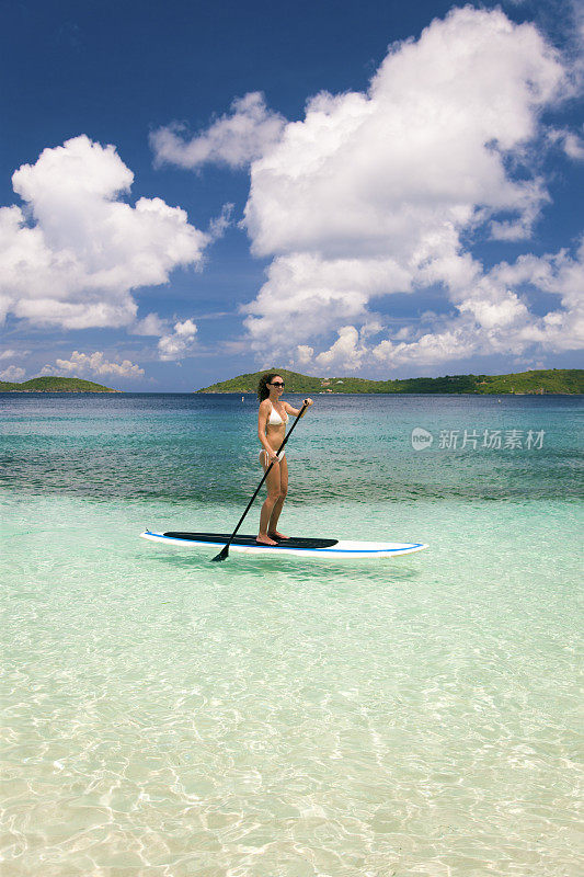 在加勒比海，一名妇女在站立式桨板上划水