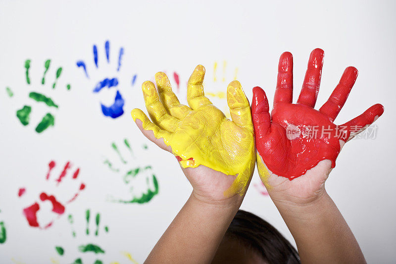 孩子的双手沾满了五颜六色的颜料