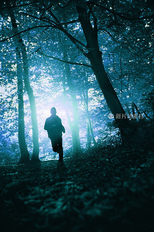 在森林里奔跑的人的剪影。2