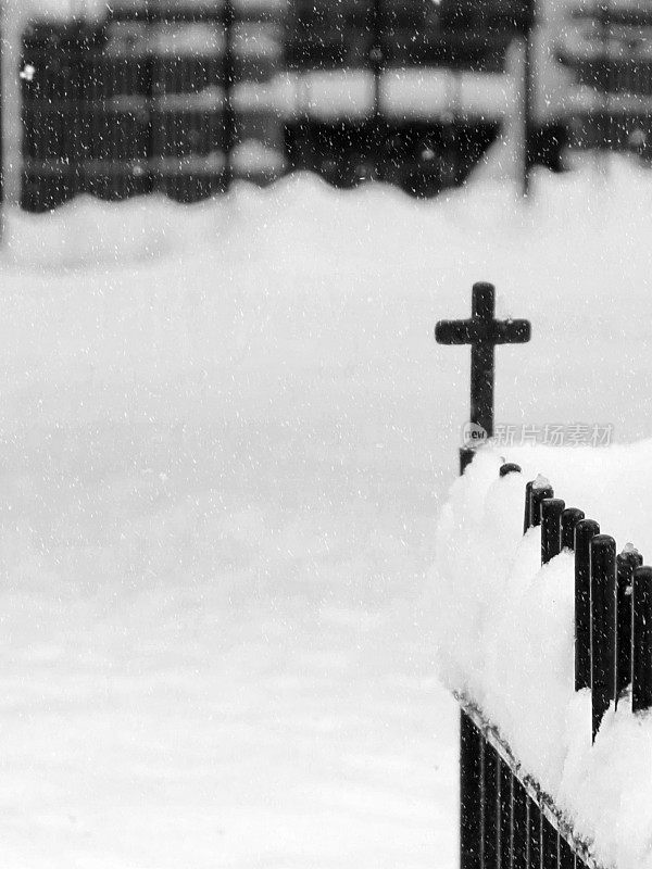 冬天教堂墓地黑色金属栅栏上的十字装饰