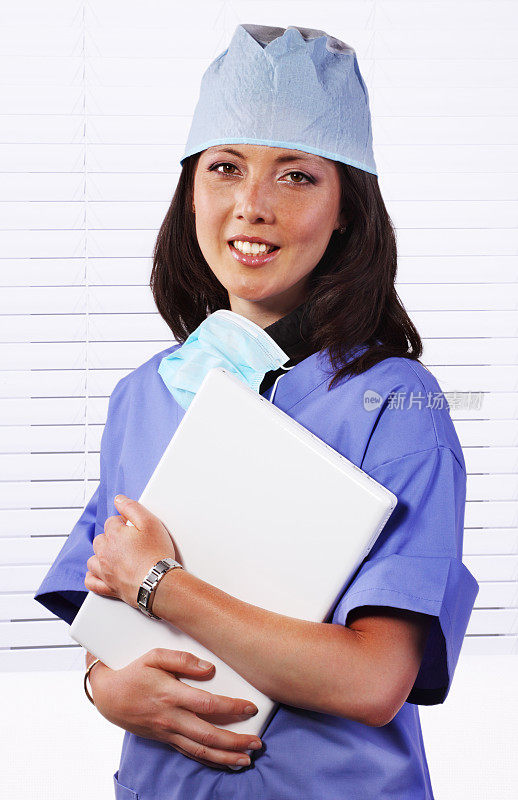 穿着手术服拿着笔记本电脑的女医生