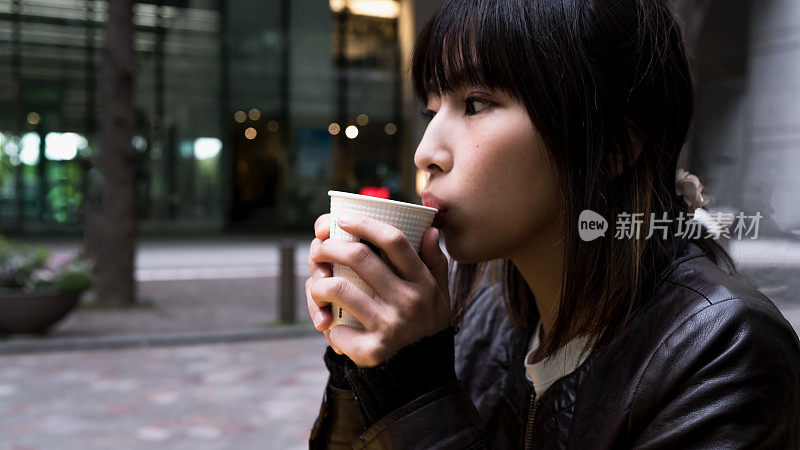 年轻女子在商业区喝咖啡