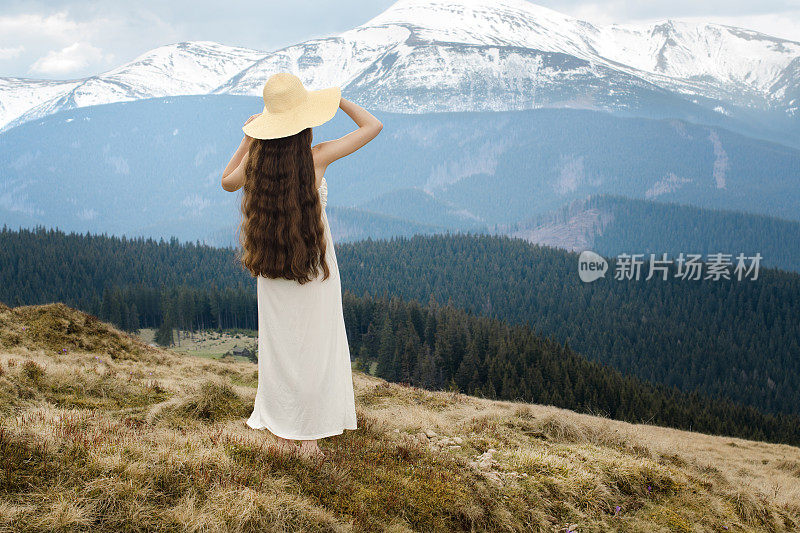 年轻女子站在山的山坡上