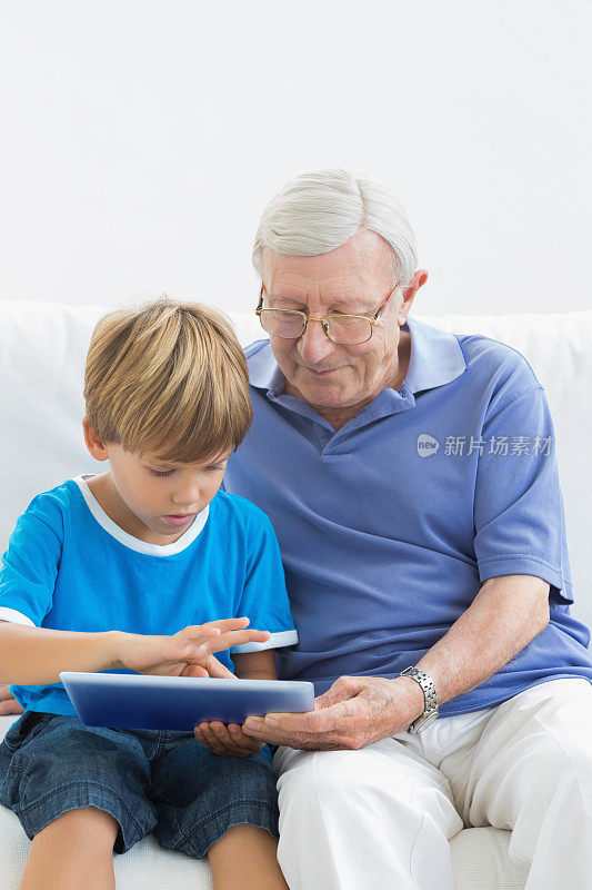 爷爷和孙子在触摸平板电脑