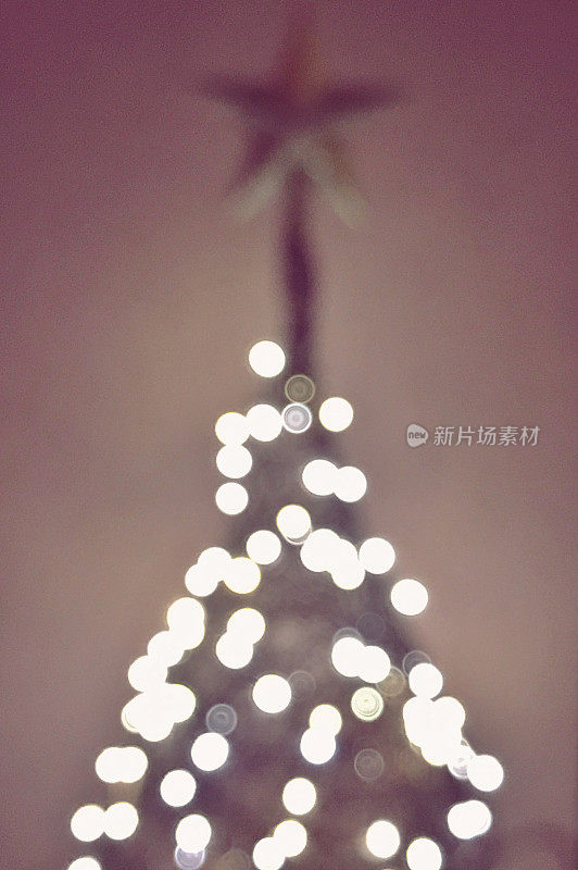 散焦圣诞LED灯在现代圣诞树与星星