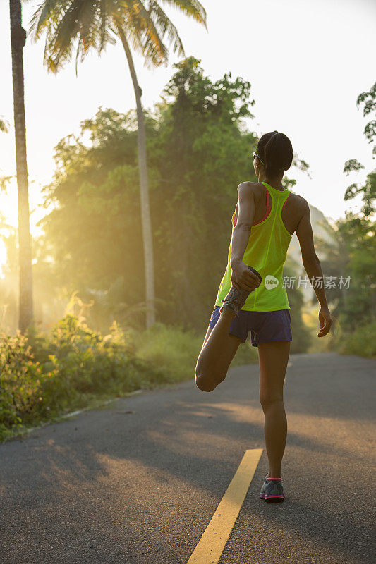 健身年轻女子跑步热身跑步前早上热带森林小径