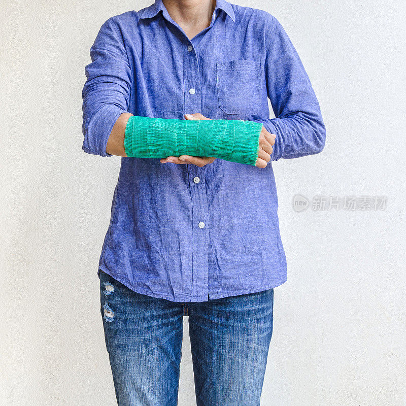 手臂上有绿色石膏的女子受伤。
