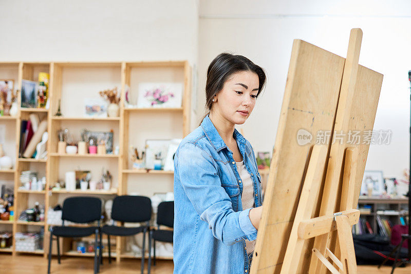 受启发的亚洲艺术家在画架上画画
