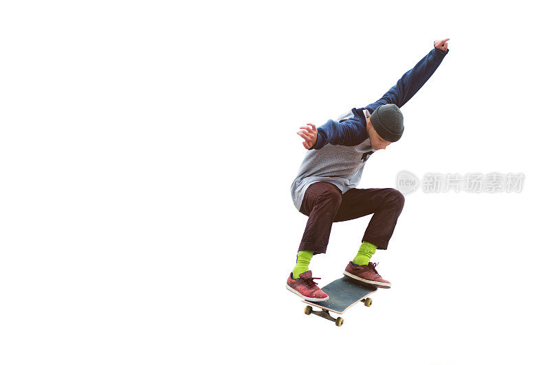 一个十几岁的滑板运动员在一个孤立的白色背景上跳奥利。街头运动与城市文化的概念