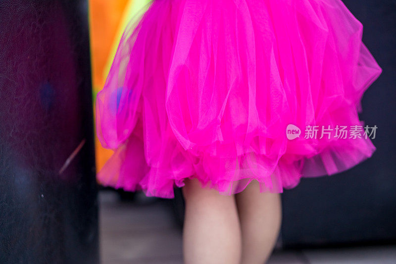 概念儿童派对，一个小女孩的特写穿着粉色芭蕾舞裙和凉鞋在公园里。聚焦深度浅。