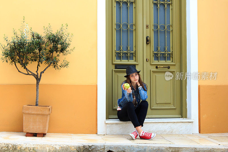希腊雅典，坐在门槛上的女孩