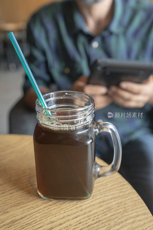 一个年轻人在咖啡店里冰咖啡杯的照片