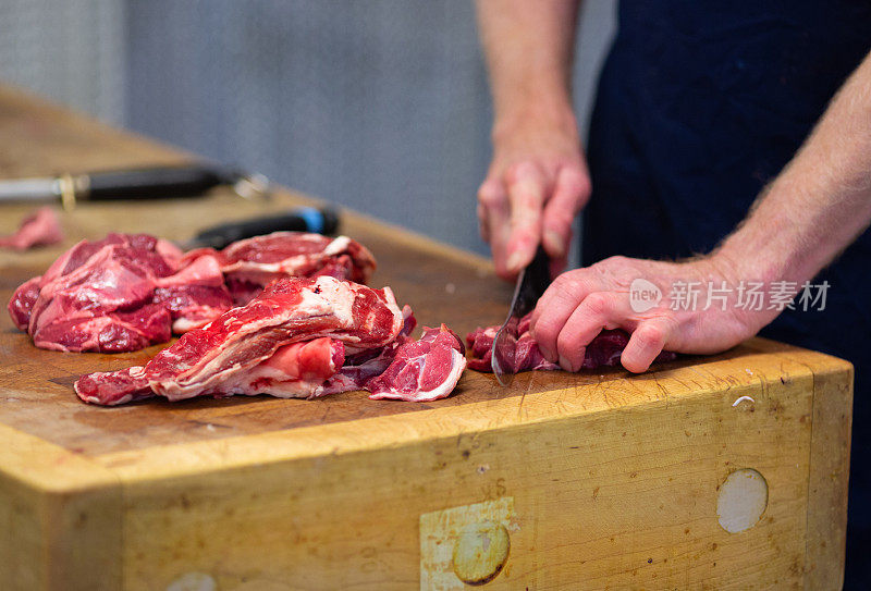 当地的屠夫正在屠夫台上准备牛肉。切成小块用来炖的