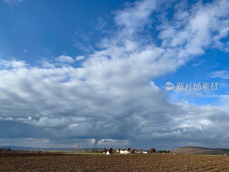 农田和典型的德国小村庄在戏剧性的天空下，一月