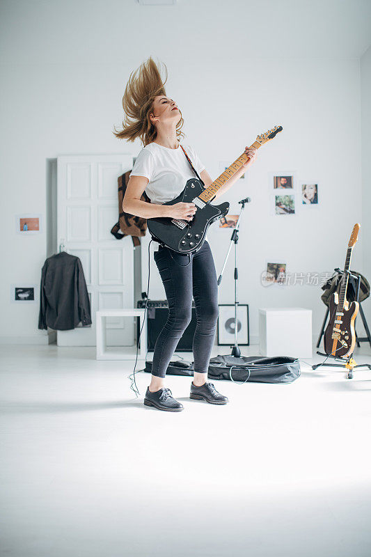 一个金发女人在音乐工作室里弹电吉他